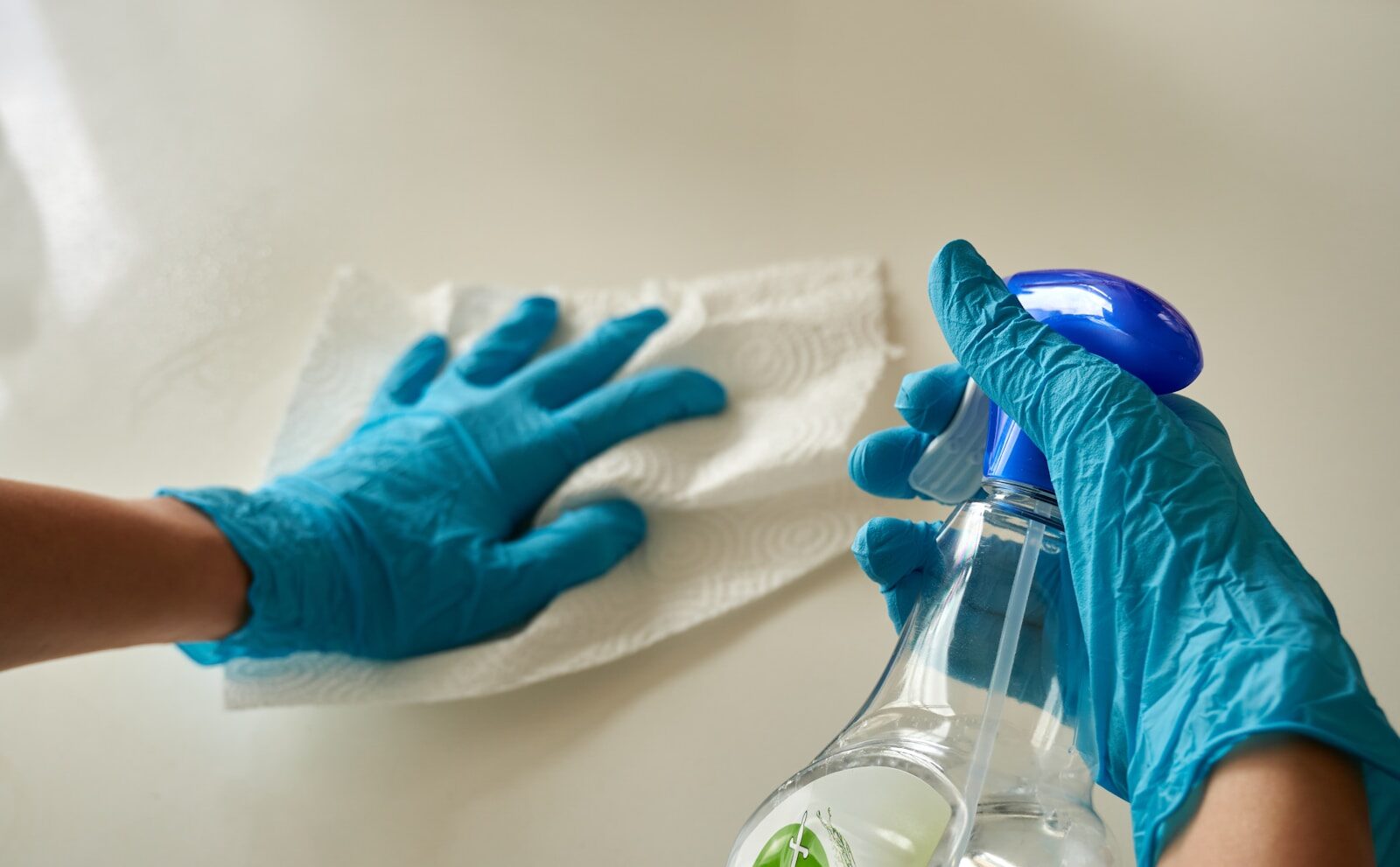 Common Problems Commercial Cleaning Solves - person holding blue textile near clear glass bottle